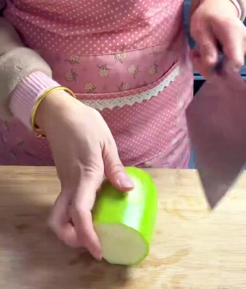 Chayote in gleichmäßige, dicke Würfel geschnitten auf einem Holzbrett.
