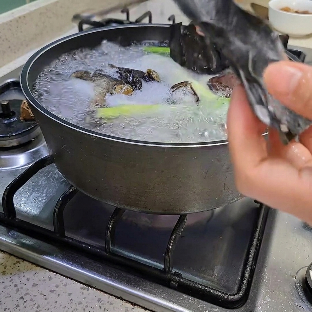 Eine Zange entfernt ein Stück Seetang aus dem kochenden Topf.