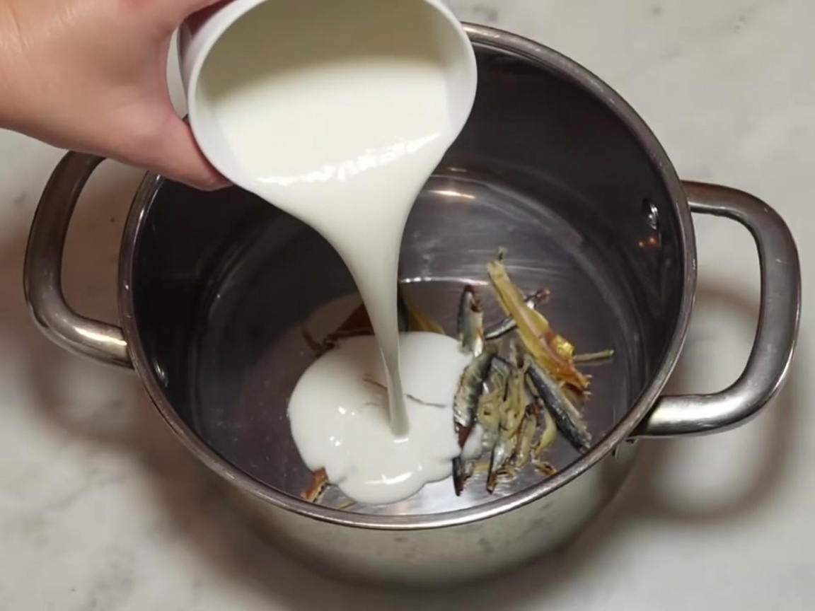 Trockene Kombu-Stücke liegen zusammen mit den Sardellen im Topf.