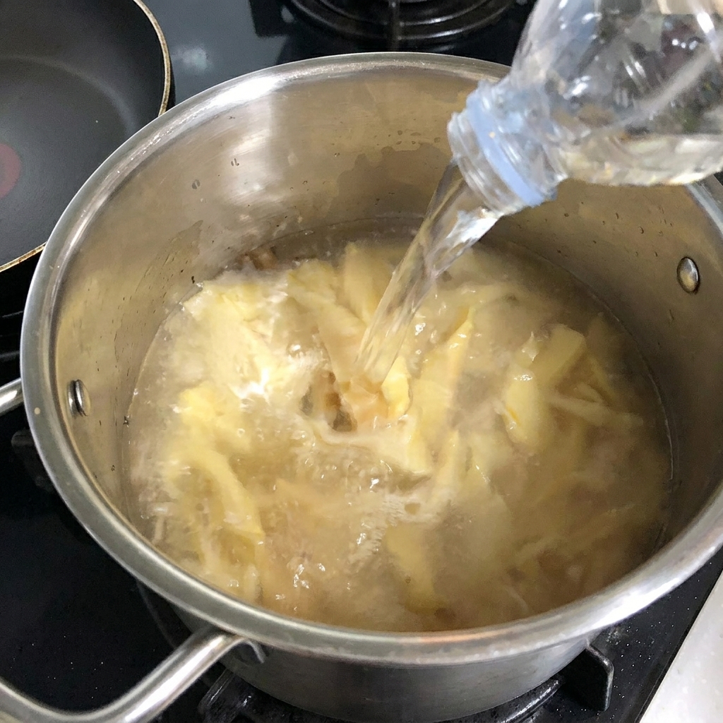 Ein Block weißer Tofu wird auf einem Holzbrett in Würfel geschnitten.