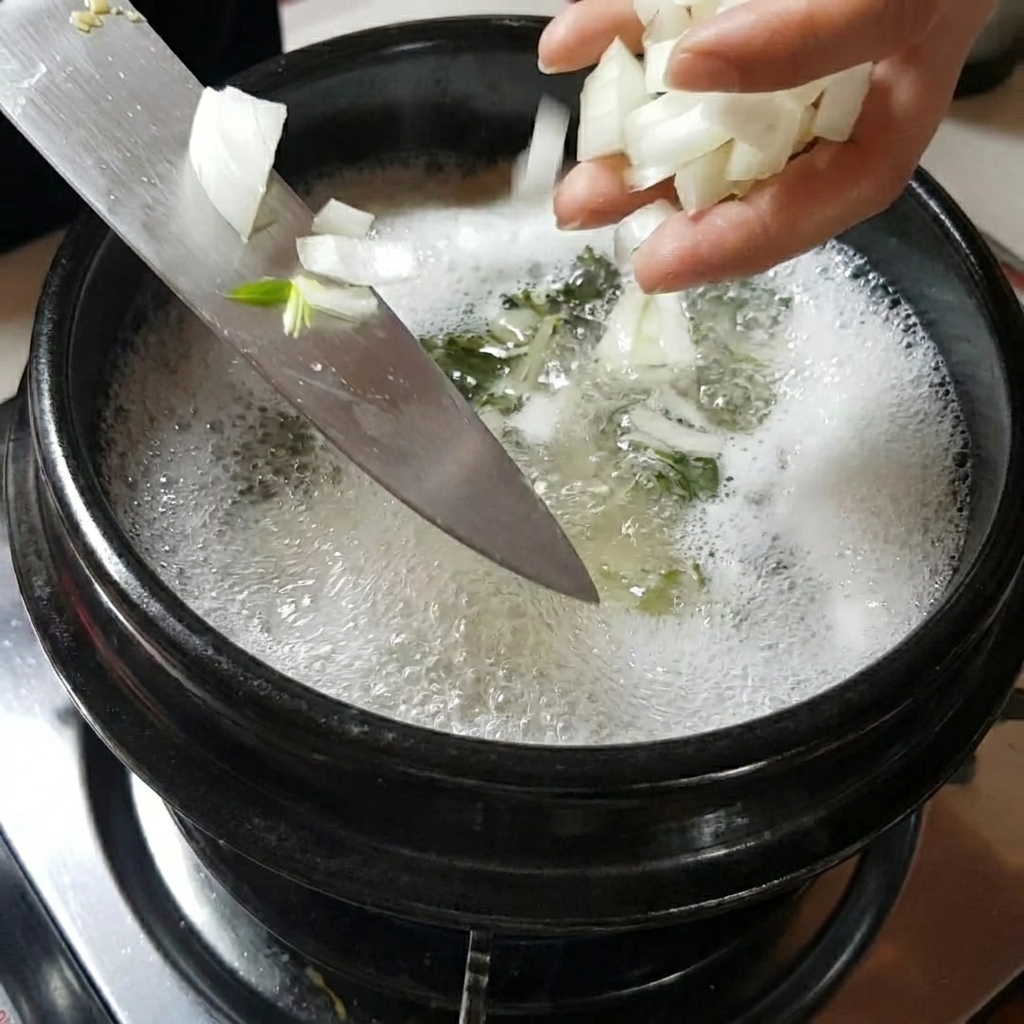Hände fügen Zwiebeln und Pilze in den köchelnden Topf hinzu.