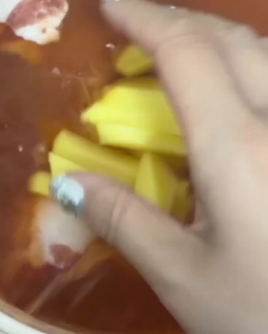 Frische Kartoffelstreifen werden in die kochende rote Brühe gegeben.