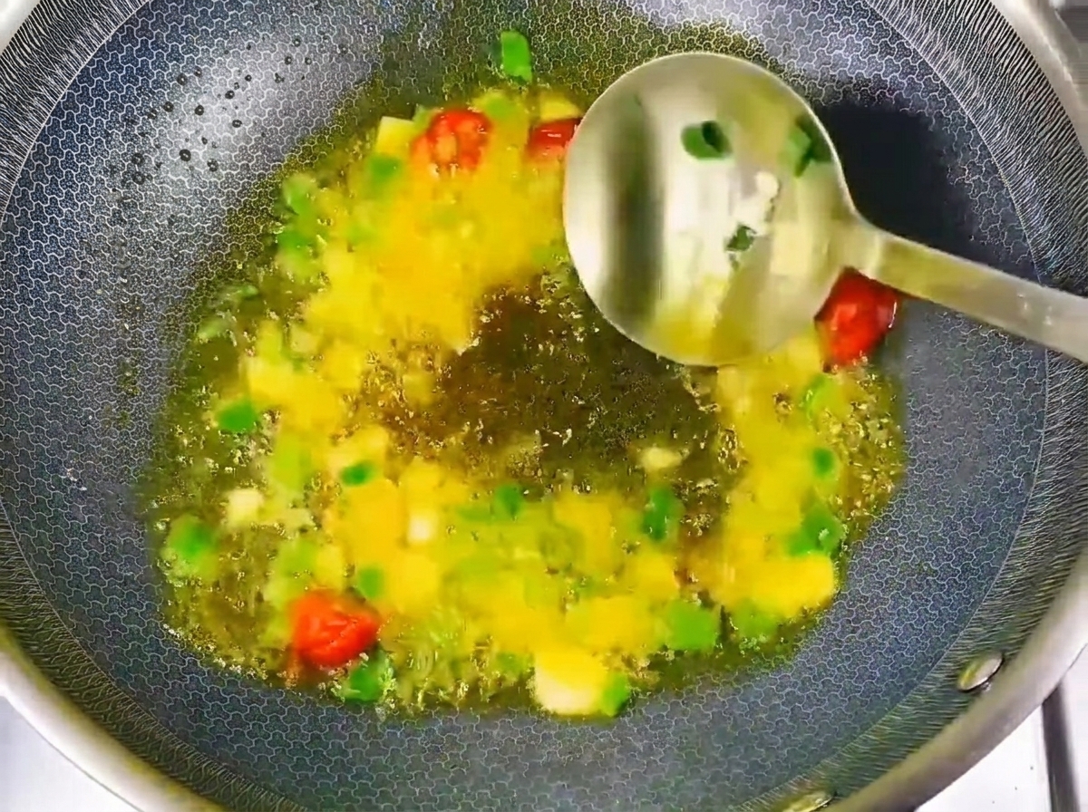 Sojapaste und Sojasauce werden zu den angebratenen Aromaten im Wok gegeben.