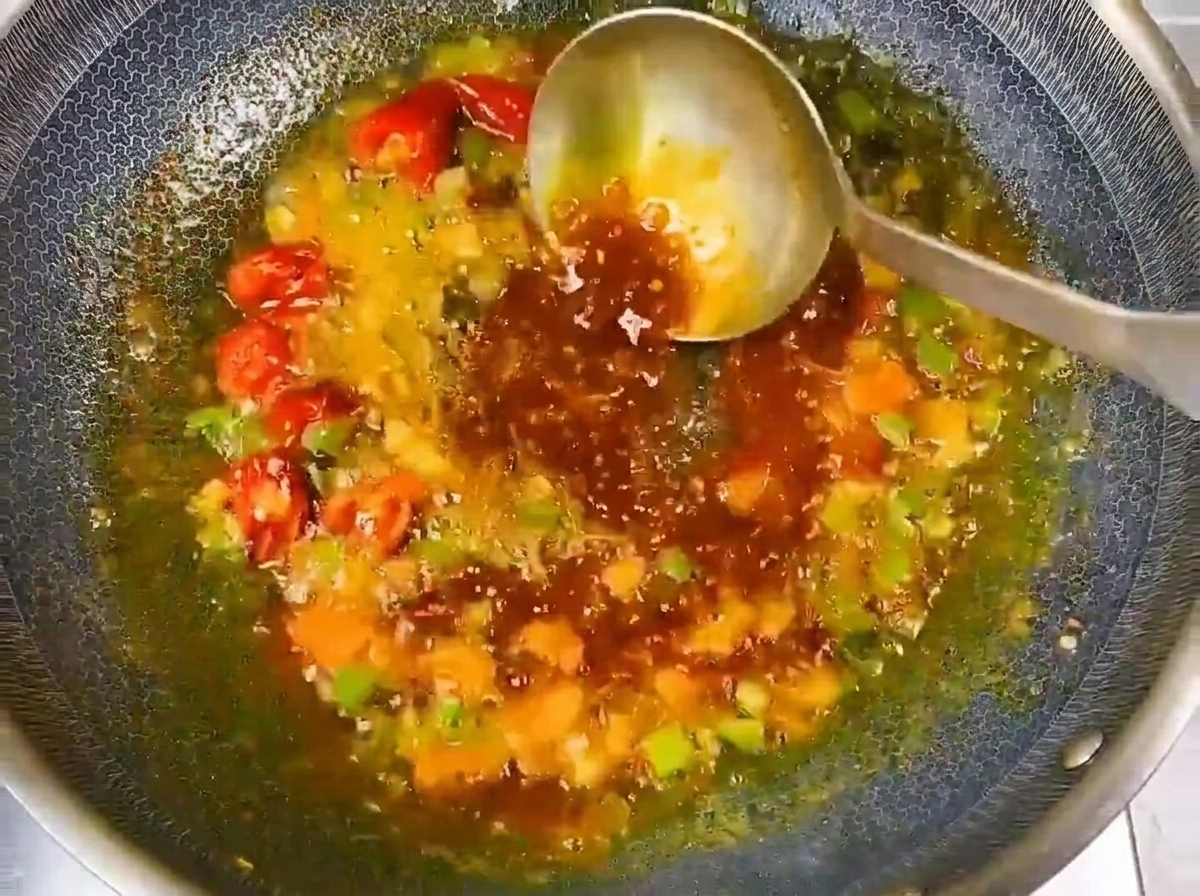 Klares Wasser wird in den gewürzten Wok-Ansatz gegossen, um eine geschmackvolle Brühe zu bilden.