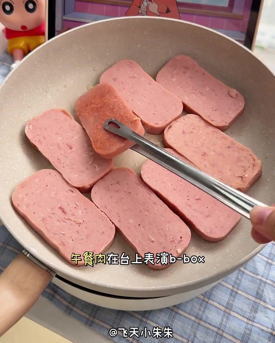 Goldbraun gebratene Spam-Scheiben in einer beschichteten Pfanne.