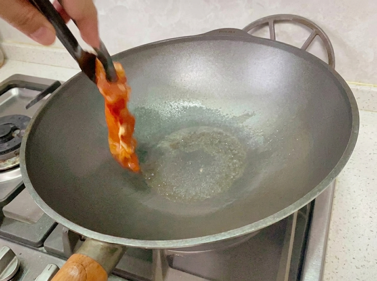 Mariniertes Hähnchen gart in einer Pfanne bei mittlerer bis niedriger Hitze.