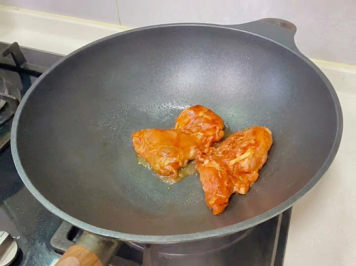 Ein fertig zusammengebauter Teriyaki-Hähnchenburger auf einem Holzbrett.
