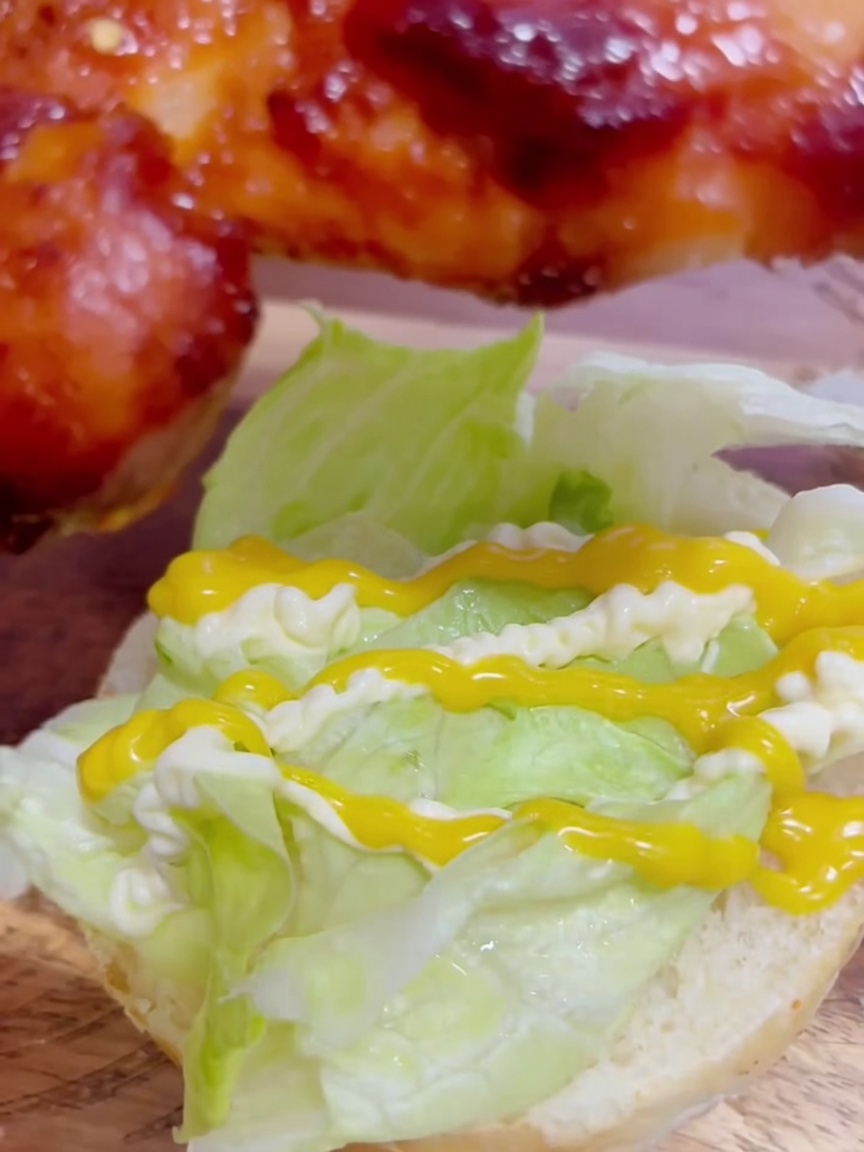 Ein Stück glasiertes Teriyaki-Hähnchen wird auf den Salat mit Honig-Senf und Mayonnaise gelegt.