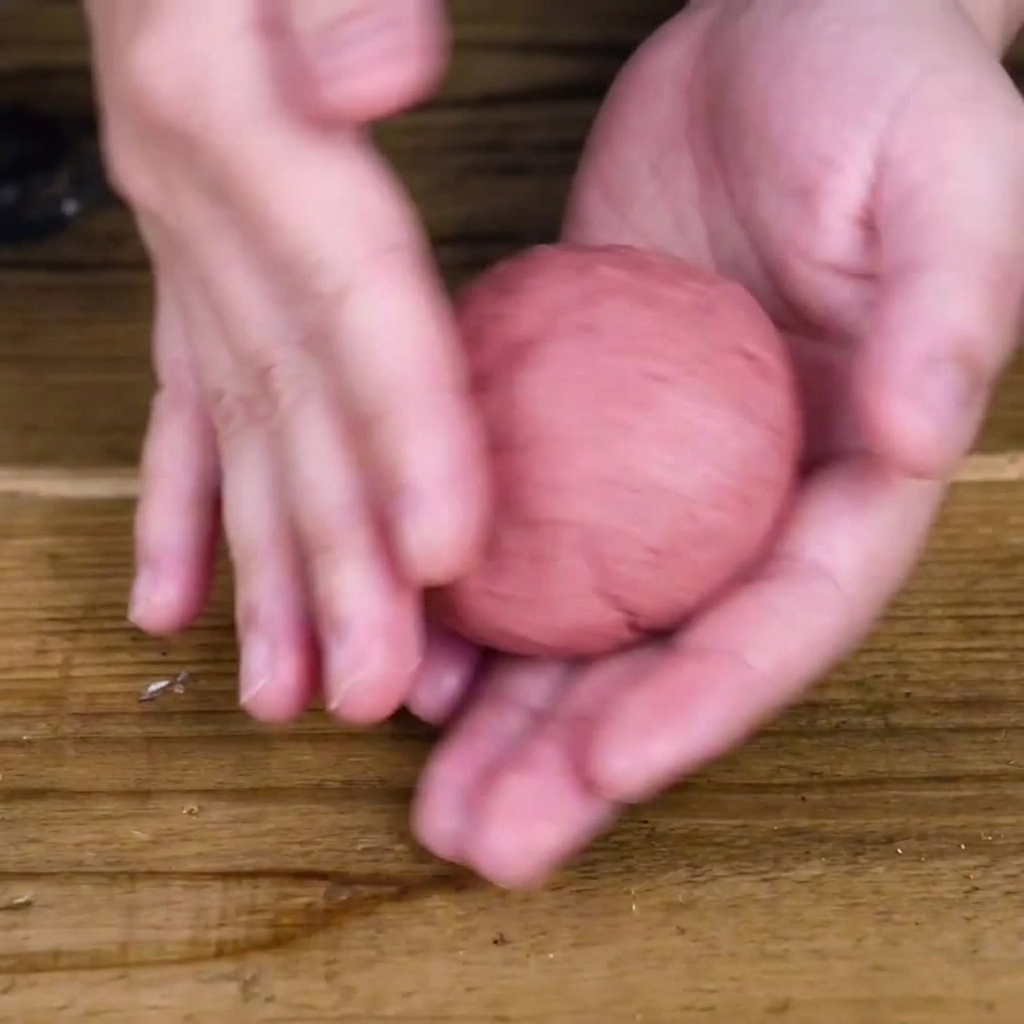 Hände formen die Fleischmischung zu einem dicken, runden Patty.