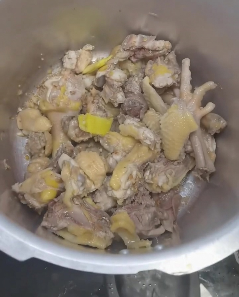 Wasser wird im Schnellkochtopf über das Huhn und die Aromen gegossen.