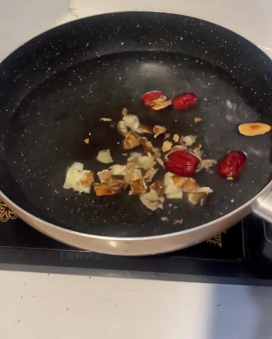 Rohe Hühnerstücke werden in einen Topf mit kaltem Wasser, Ingwer und roten Datteln gegeben.