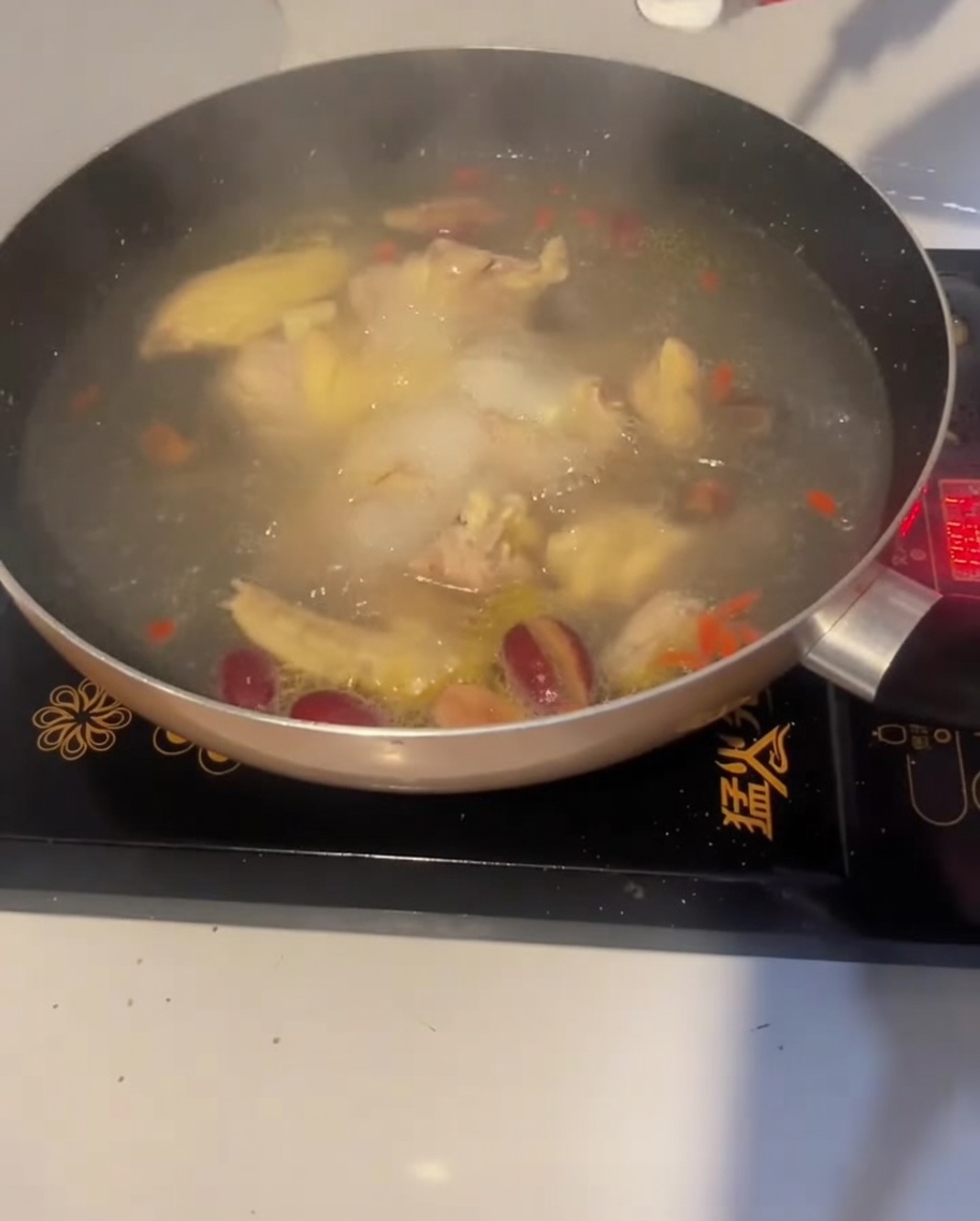 Ein Löffel Salz wird zum Würzen in die kochende Hühnersuppe gegeben.