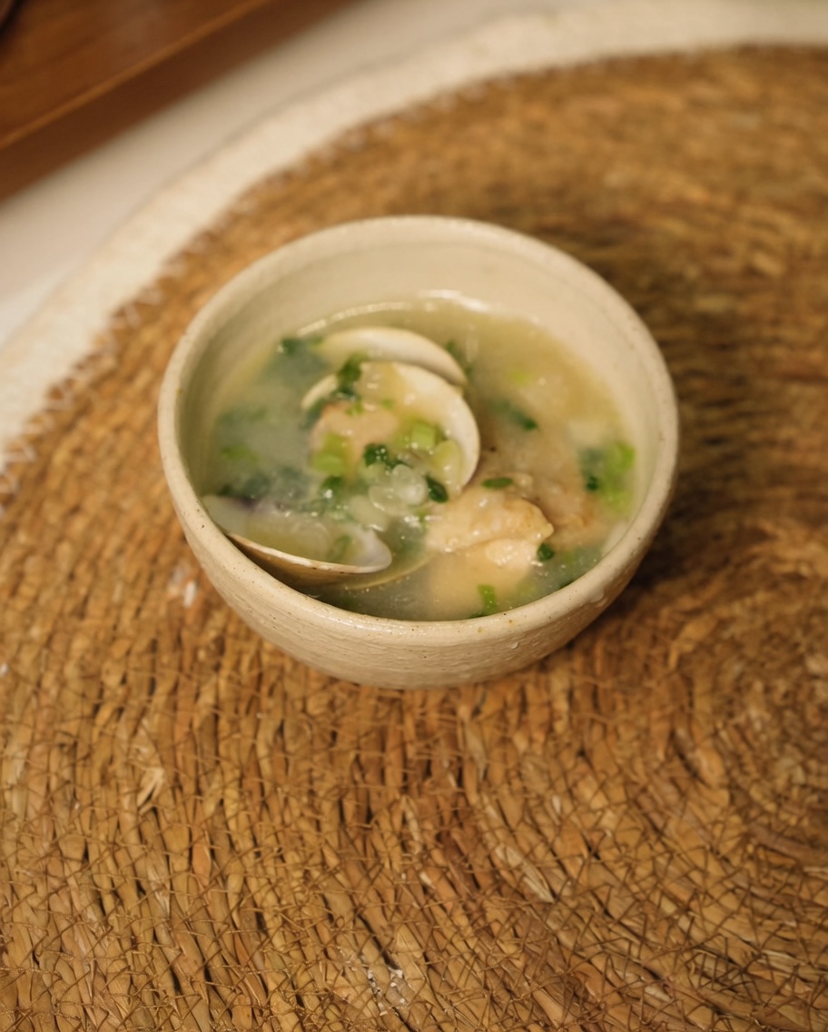 Hähnchenstücke, Zwiebeln und Knoblauch werden in der Pfanne mit kochendem Wasser übergossen.