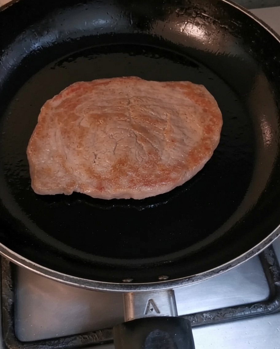 Ein Rinderfilet bräunt in einer heißen schwarzen Pfanne.