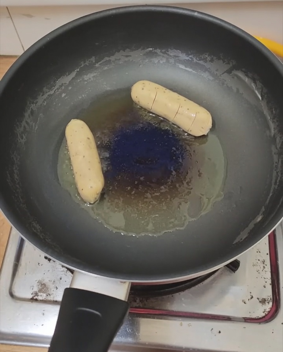 Ein Spiegelei und eine Wurst braten in der Pfanne.