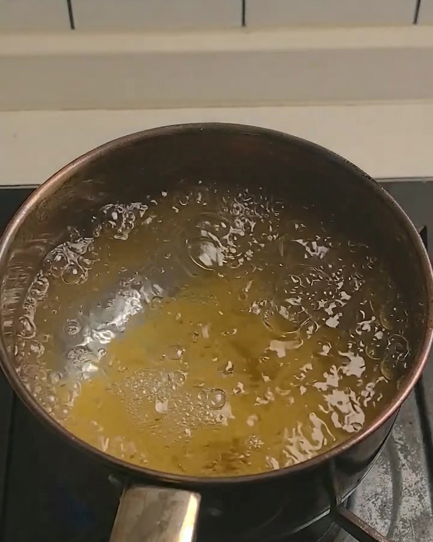 Kabocha-Kürbis wird auf einem Holzbrett in kleinere Stücke geschnitten.