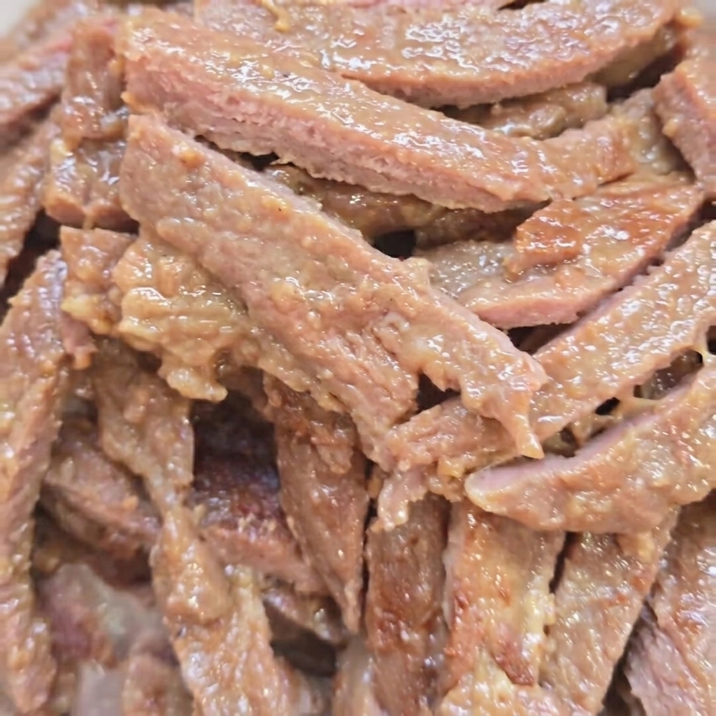 Rindfleischstreifen braten in einer Pfanne und werden braun.