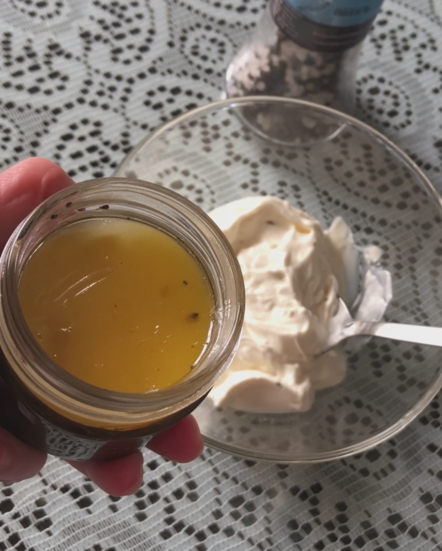 Ein Löffel schwarze Trüffelsauce wird zu Schmand in eine Schüssel gegeben.
