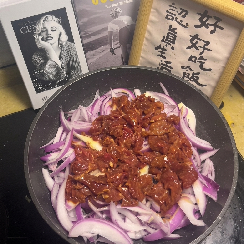 Eine Saucenmischung mit sichtbaren Knoblauch- und Chilistückchen wird über das rohe Fleisch und die Zwiebeln in der Pfanne gegossen.