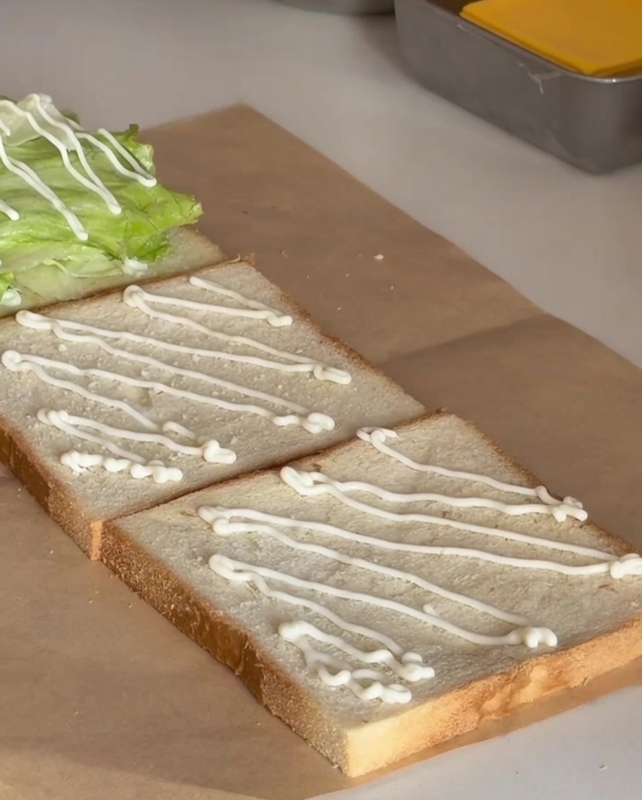 Ein saftiges, goldbraun gebratenes Hähnchenfilet auf dem Salat.