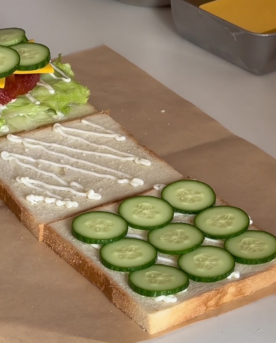 Nahaufnahme von dünn geschnittenen, frischen Gurken auf dem Sandwich.