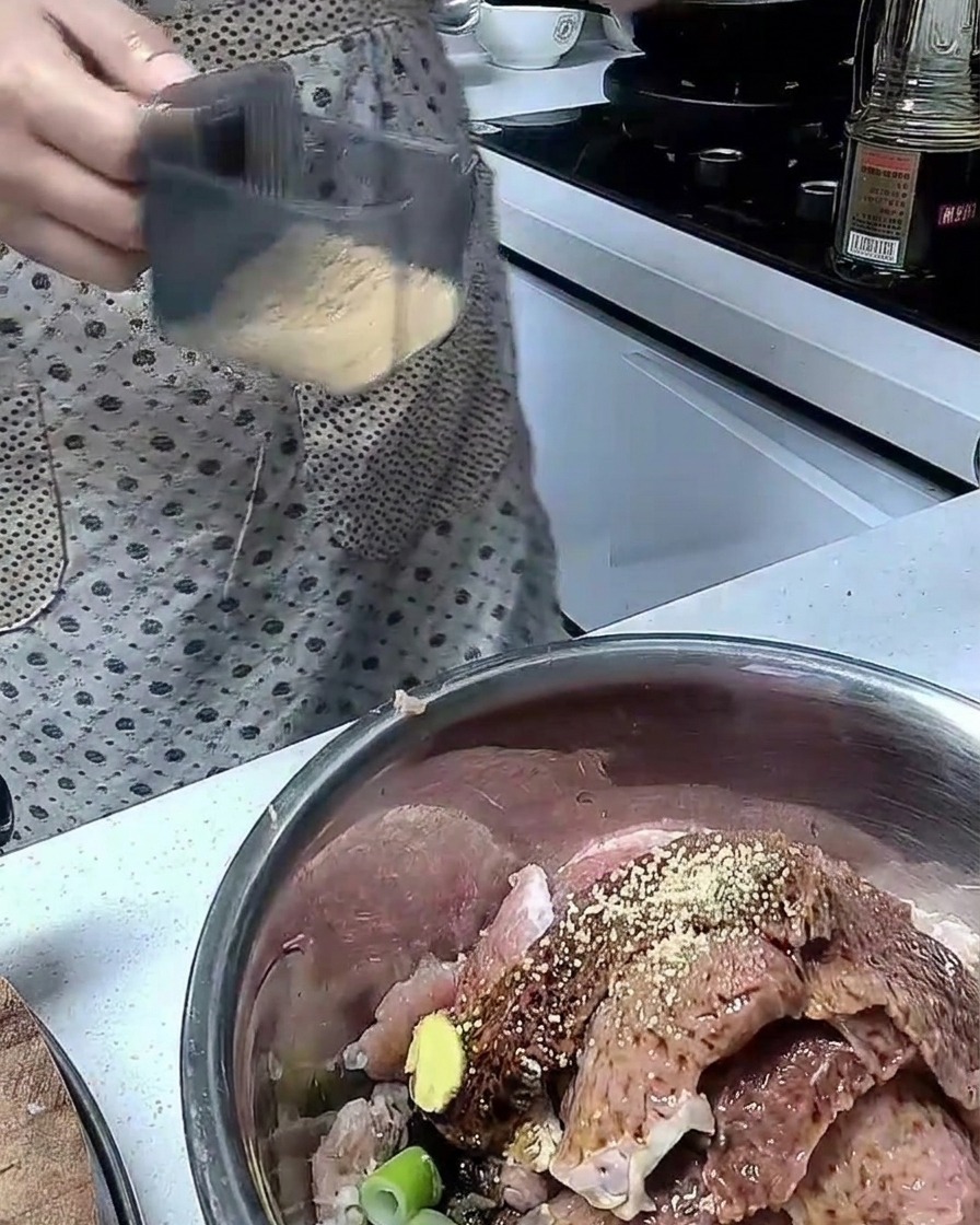 Fleisch wird in einer Schüssel mit Gewürzen vermengt.