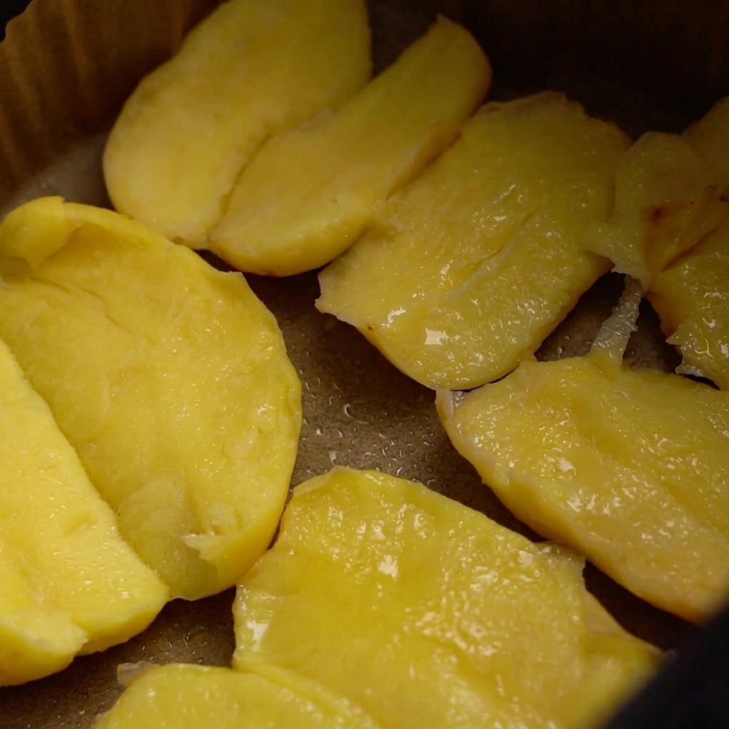 Kartoffeln in einem Heißluftfritteusen-Korb, überzogen mit Öl, bestreut mit grobem Salz und Sesamsamen.
