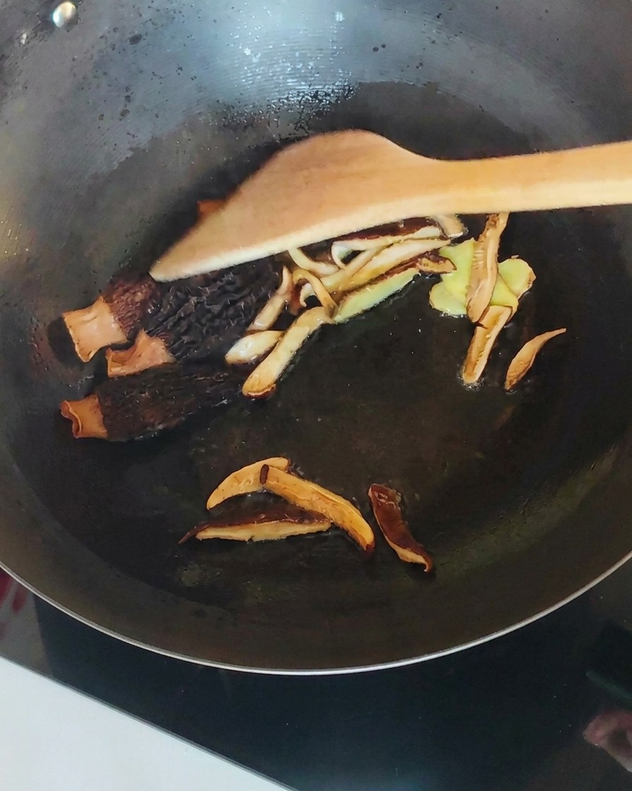 Gebratenes Hähnchen mit Pilzen und Ingwer im Wok.