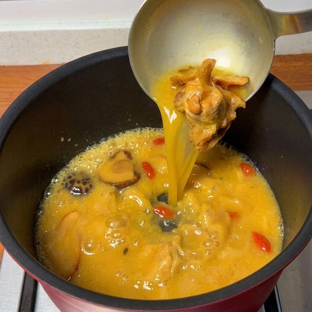 Herzhafte Hähnchensuppe kocht in einem Topf und ist bereit für die Nudeln.
