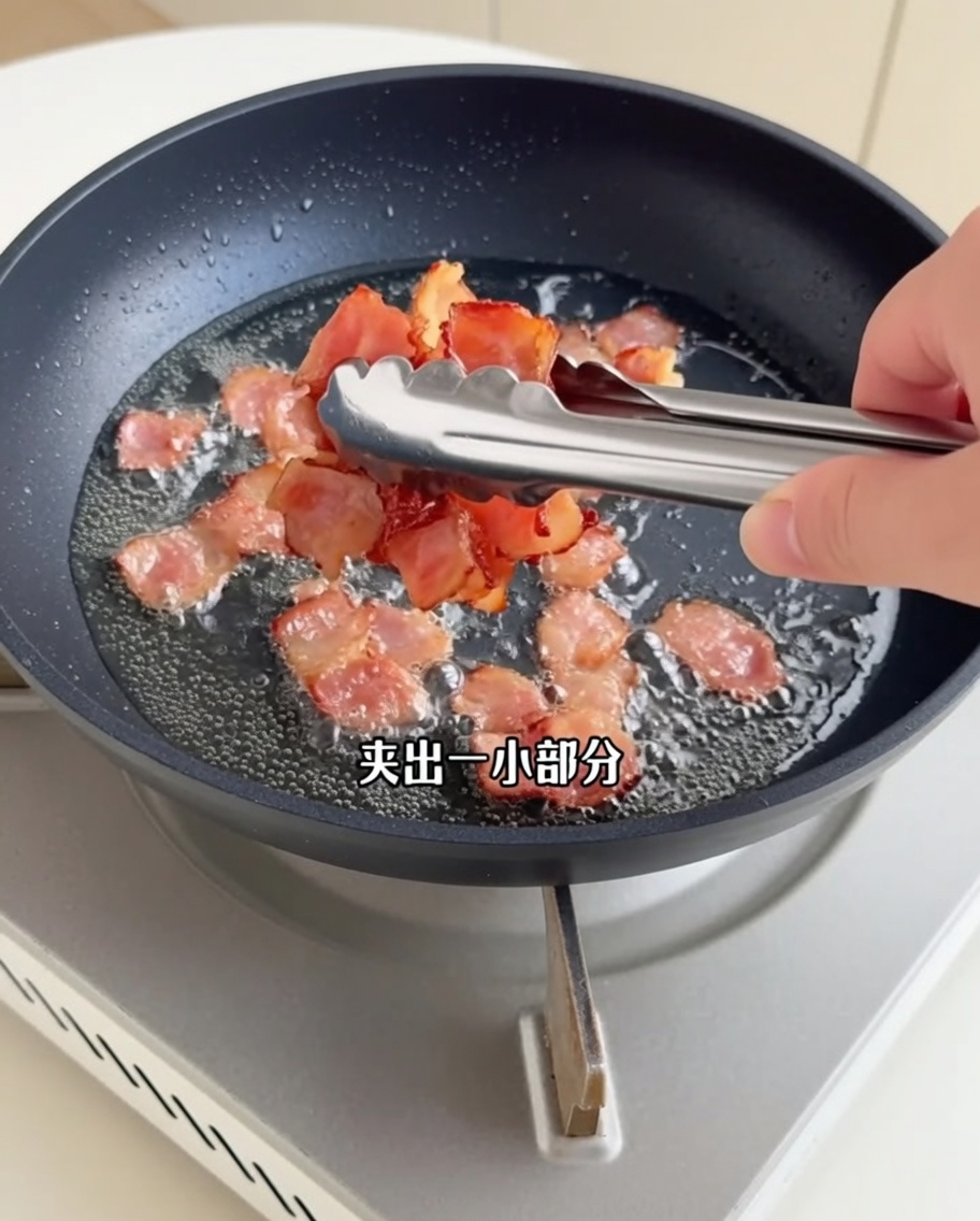 Knusprig gebratene Speckstücke werden mit einer Küchenzange aus der Pfanne gehoben.