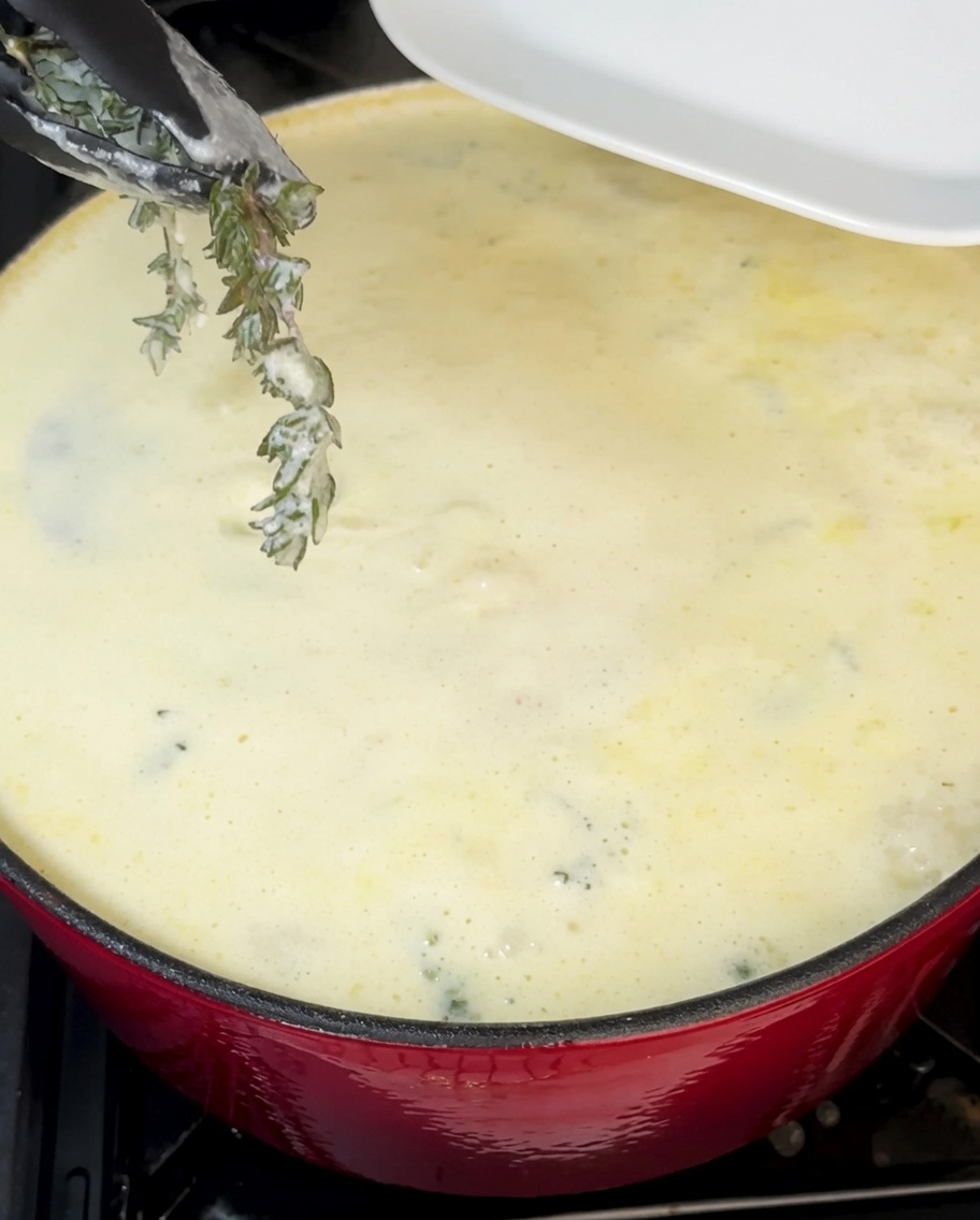 Frisch gehackter grüner Schnittlauch wird unter die cremige Clam Chowder gerührt.