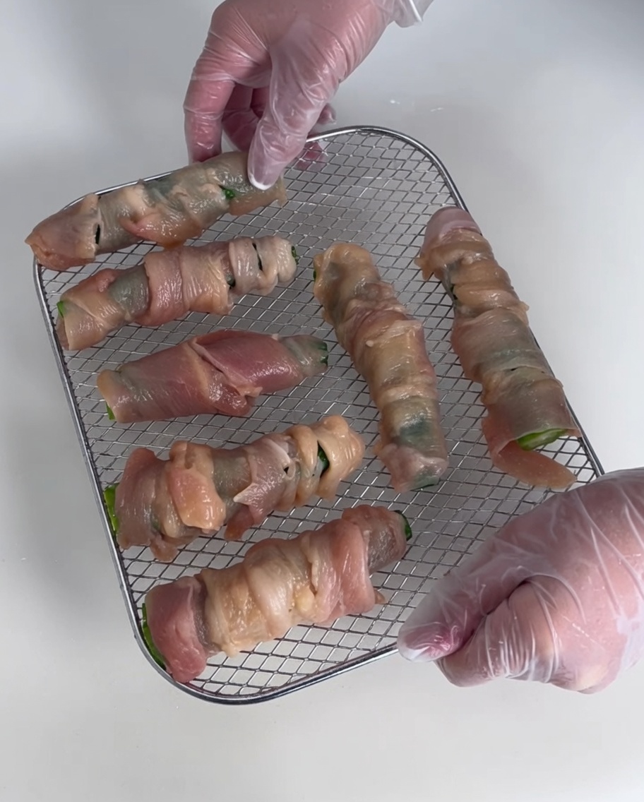Mehrere Okra-Hähnchen-Wraps liegen auf einem Drahtgitter zum Trocknen.