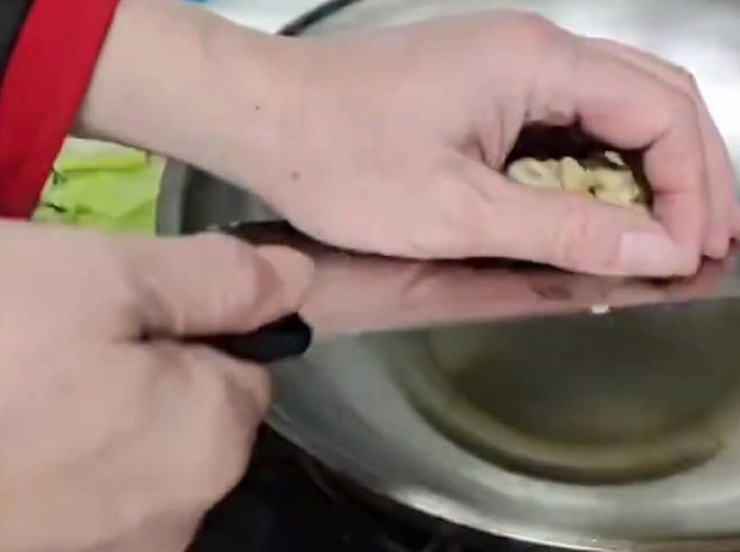 Bambussprossenstiele werden in einem heißen Metall-Wok mit Öl angebraten.