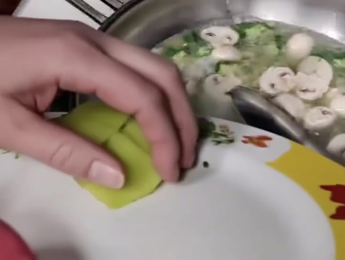 Bambussprossenscheiben werden der Mischung aus Fleischbällchen, Pilzen und Okra im Wok beigefügt.