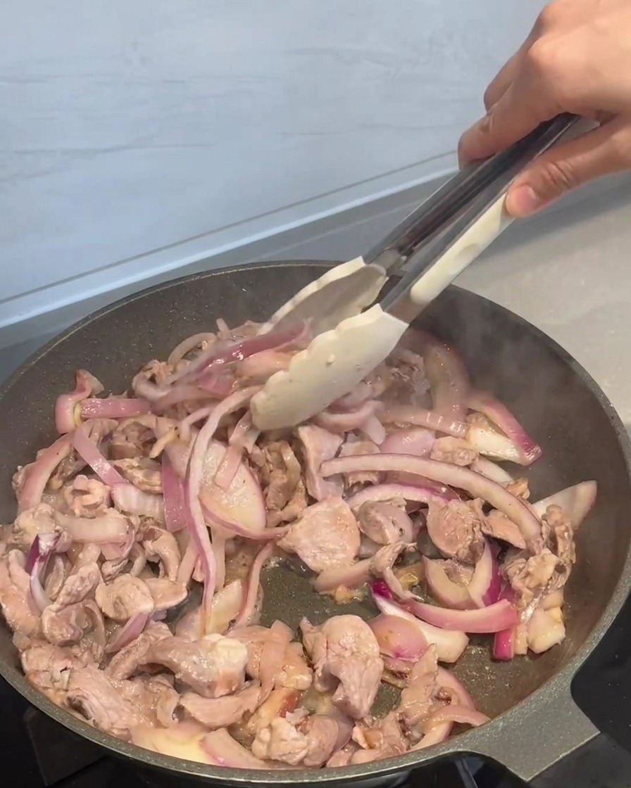 Sauce wird über das Fleisch gegossen.