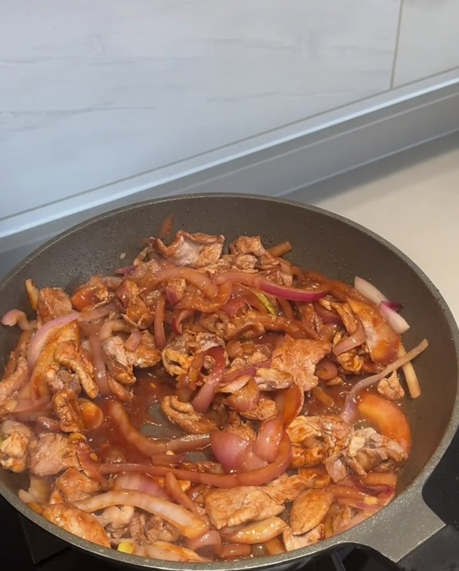 Chilipulver wird über die Pfanne gestreut.
