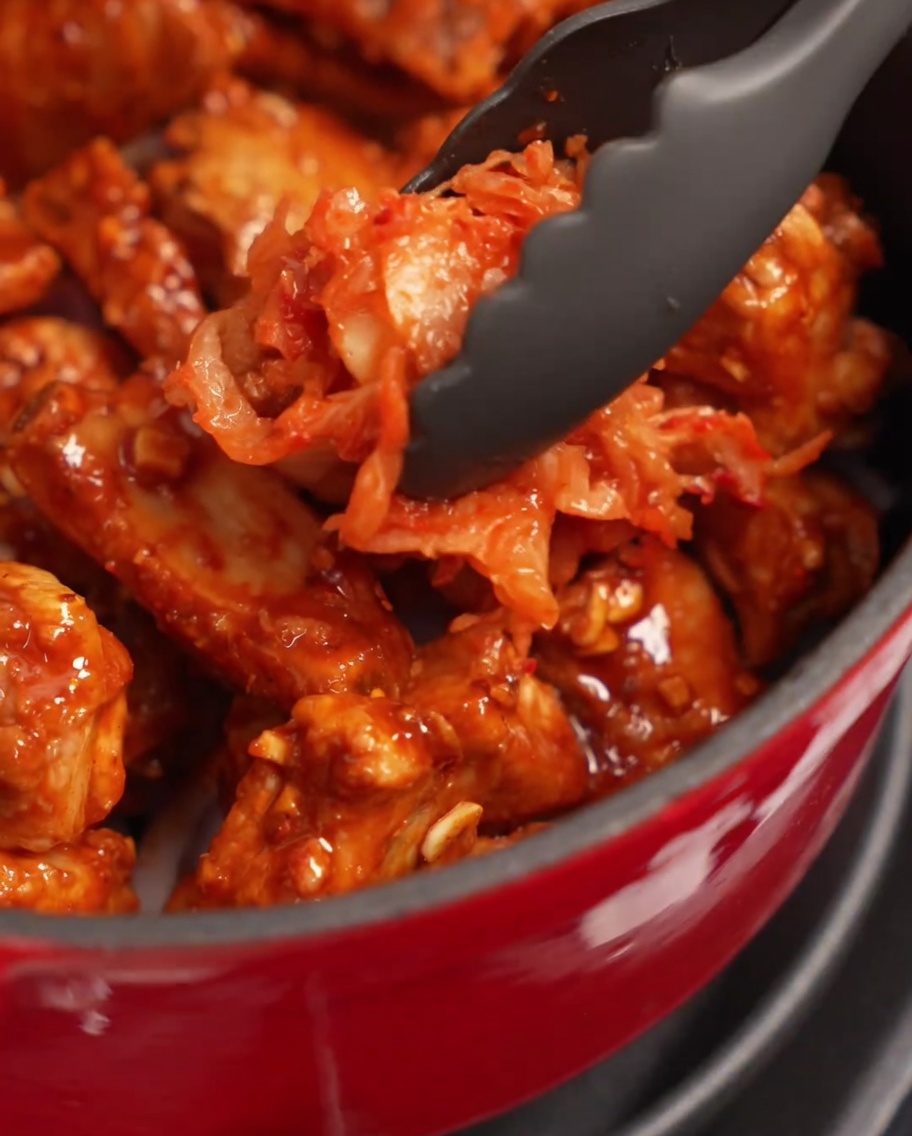 Eine große Portion Kimchi wird auf die Rippchen im Topf gegeben.