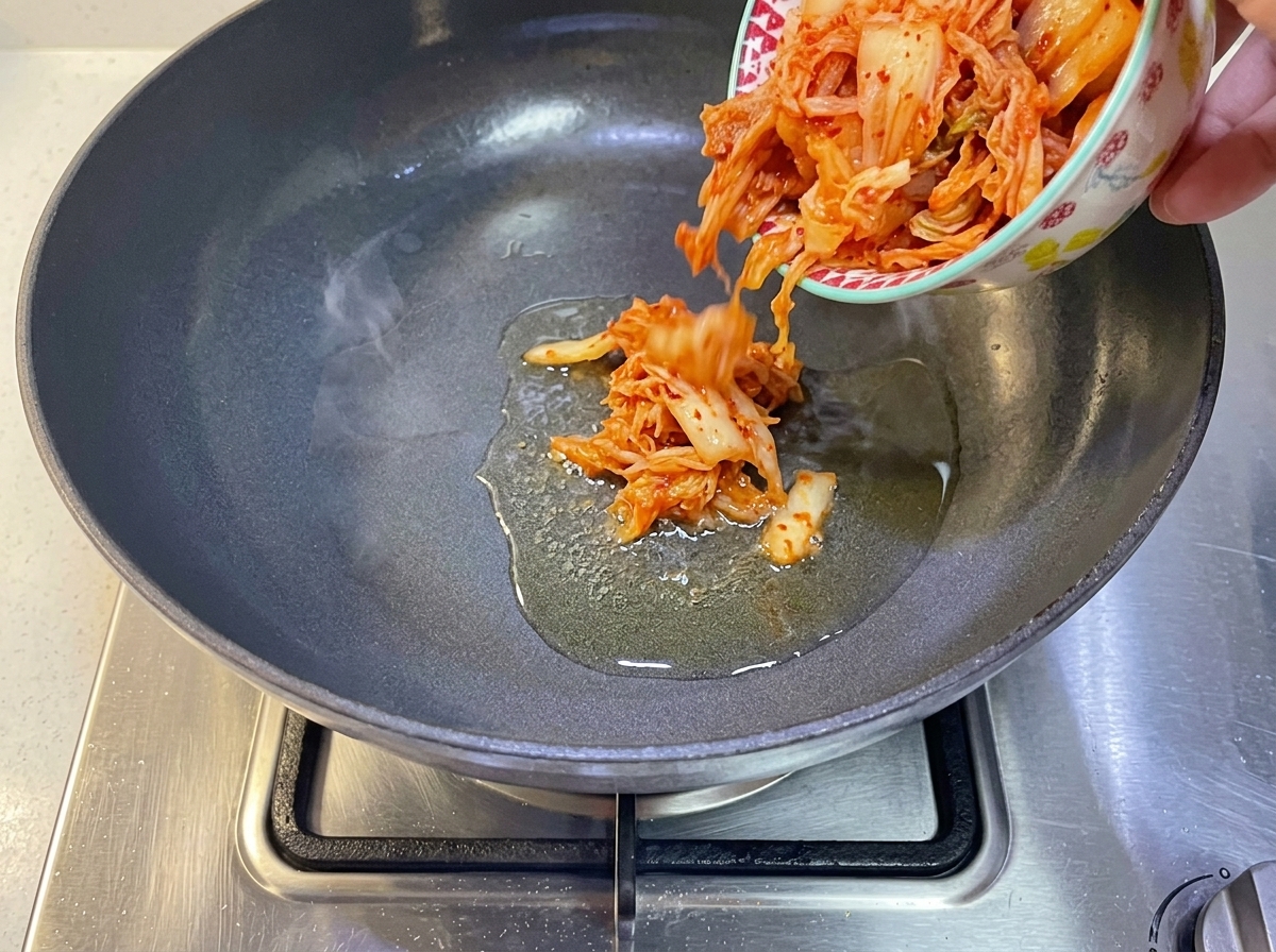Koreanisches Kimchi wird in eine Pfanne mit heißem Öl gegeben.
