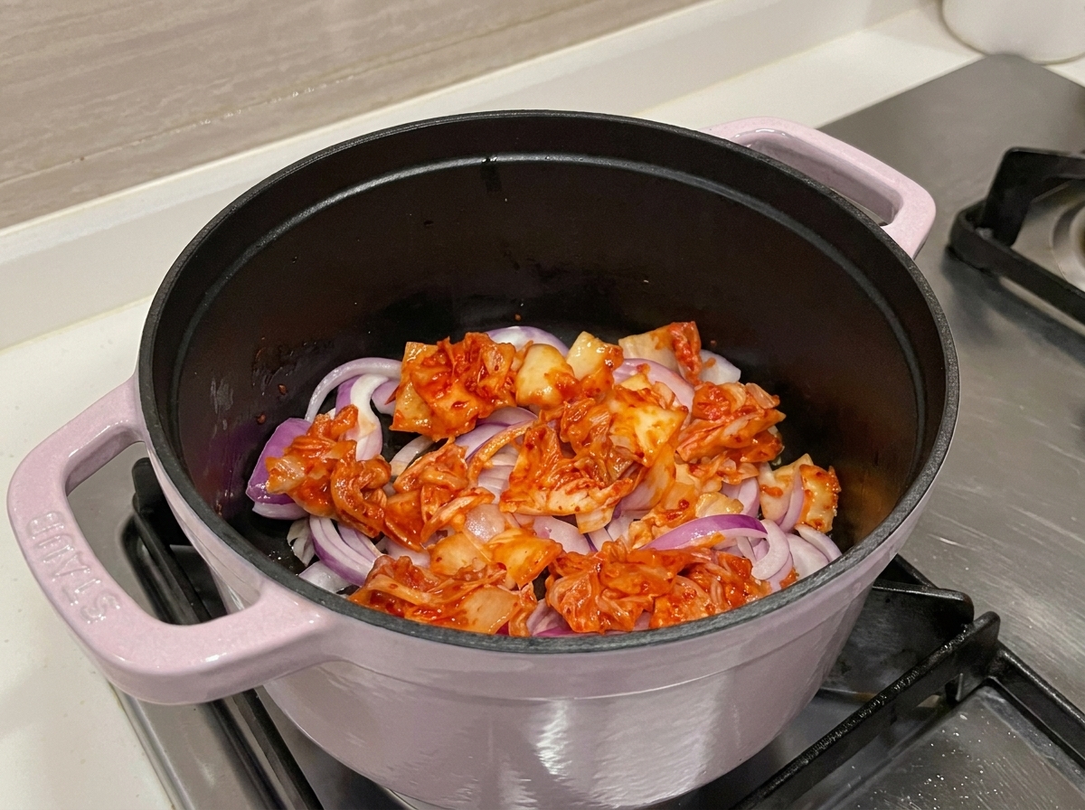 Vibrierend roter Kimchi und Zwiebeln in einem Topf.