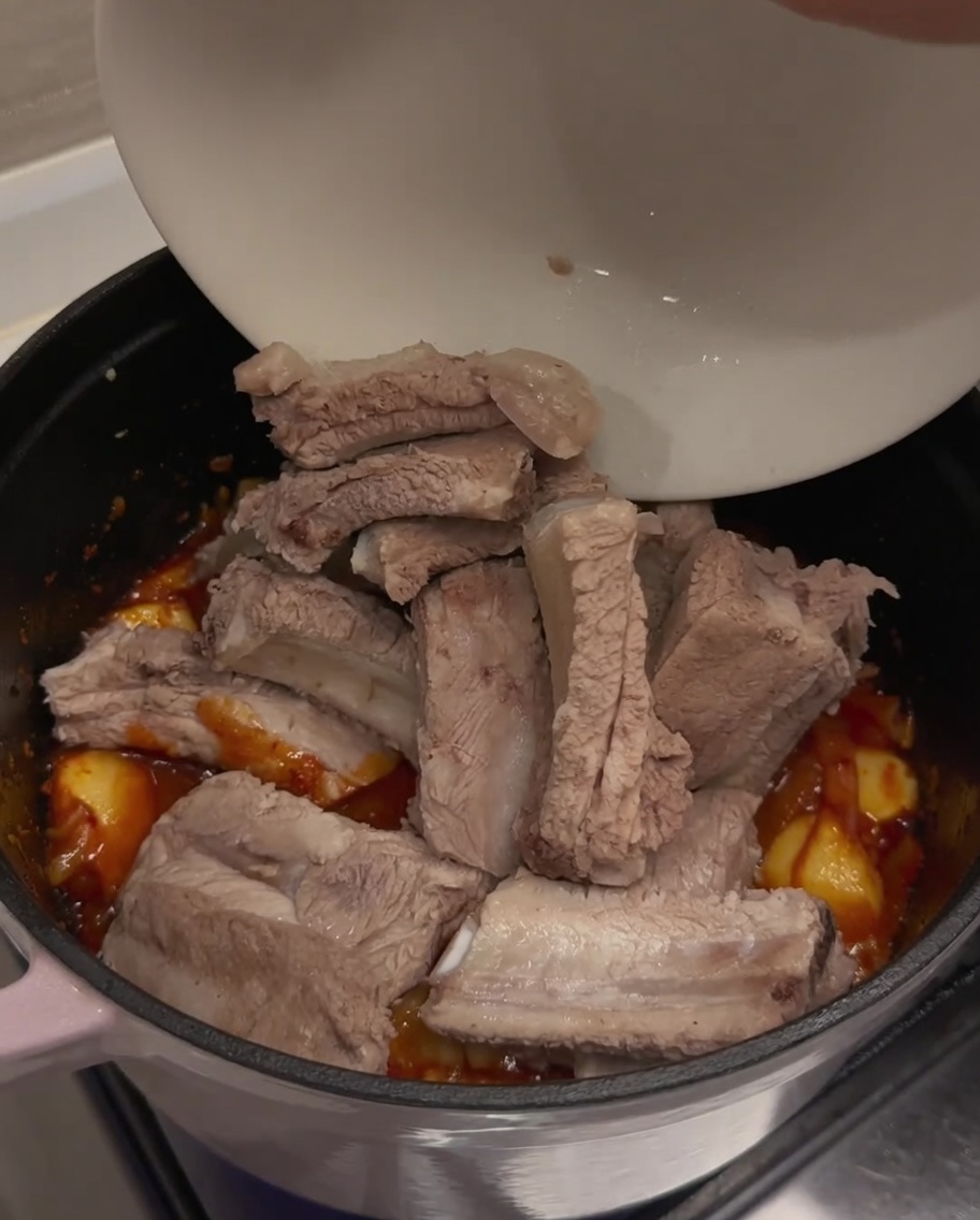 Blanchierte Rippchen werden in den Topf gegeben.
