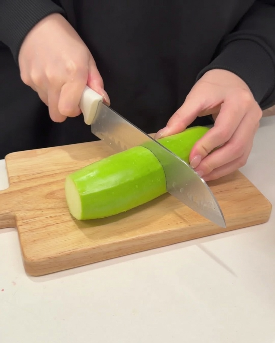 Zucchini wird in Halbmonde geschnitten.