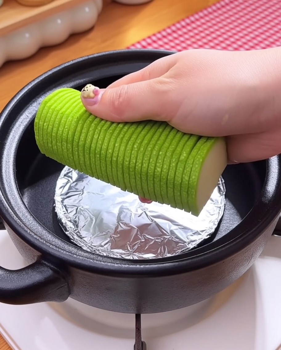 Enoki-Pilze und rohe Muscheln werden über der Gemüseschicht in den Topf gegeben.
