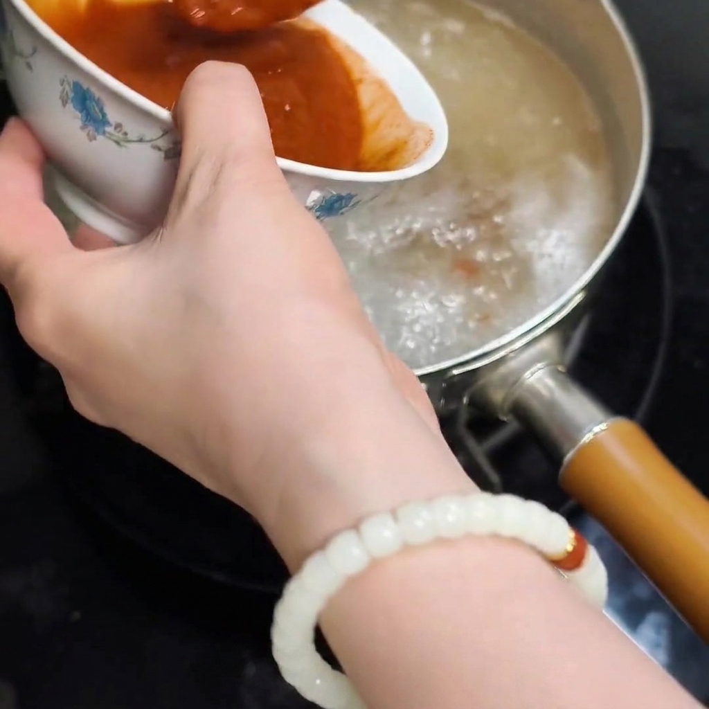 Die glatte Pastenmischung wird in das kochende Reiswasser gegeben.