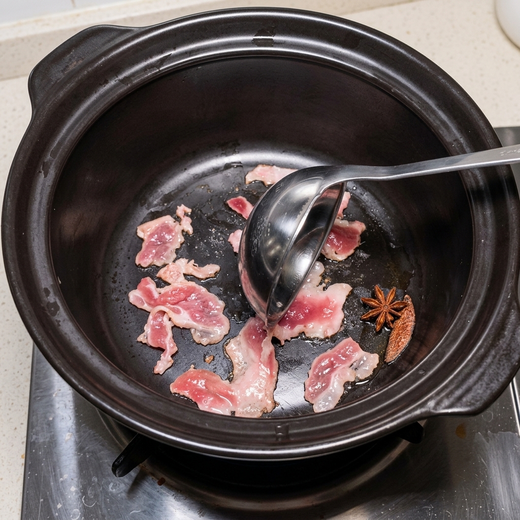 Anbratender Schweinebauch im heißen Tontopf.