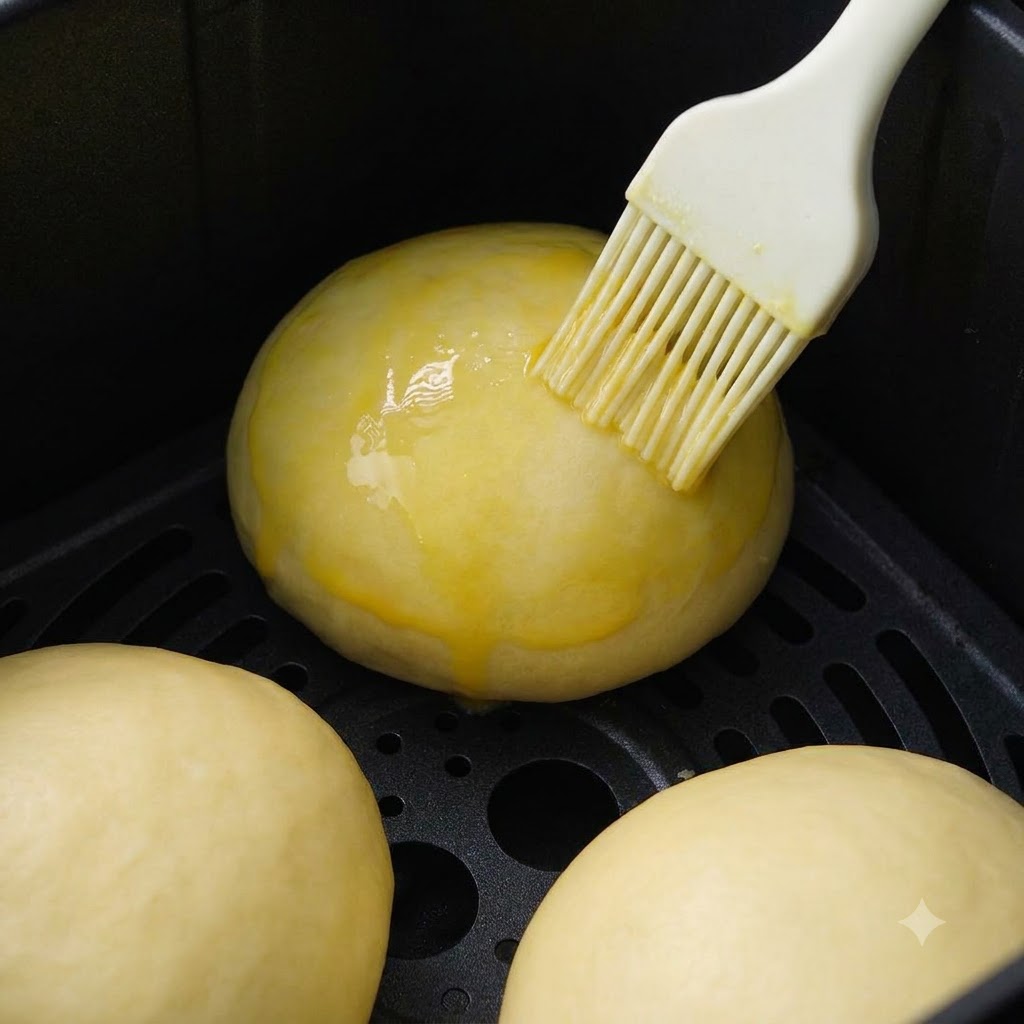 Weisse Sesamsamen werden auf die Oberseite der geformten Brötchen gestreut.