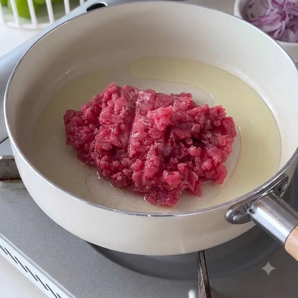 Rohes Hackfleisch in einer heißen weißen Pfanne mit Öl.