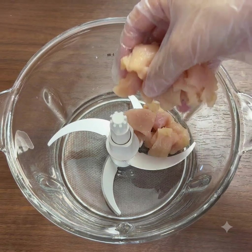 Hähnchenbruststücke und frisches Gemüse in einer Glas-Mixschüssel mit Messern.