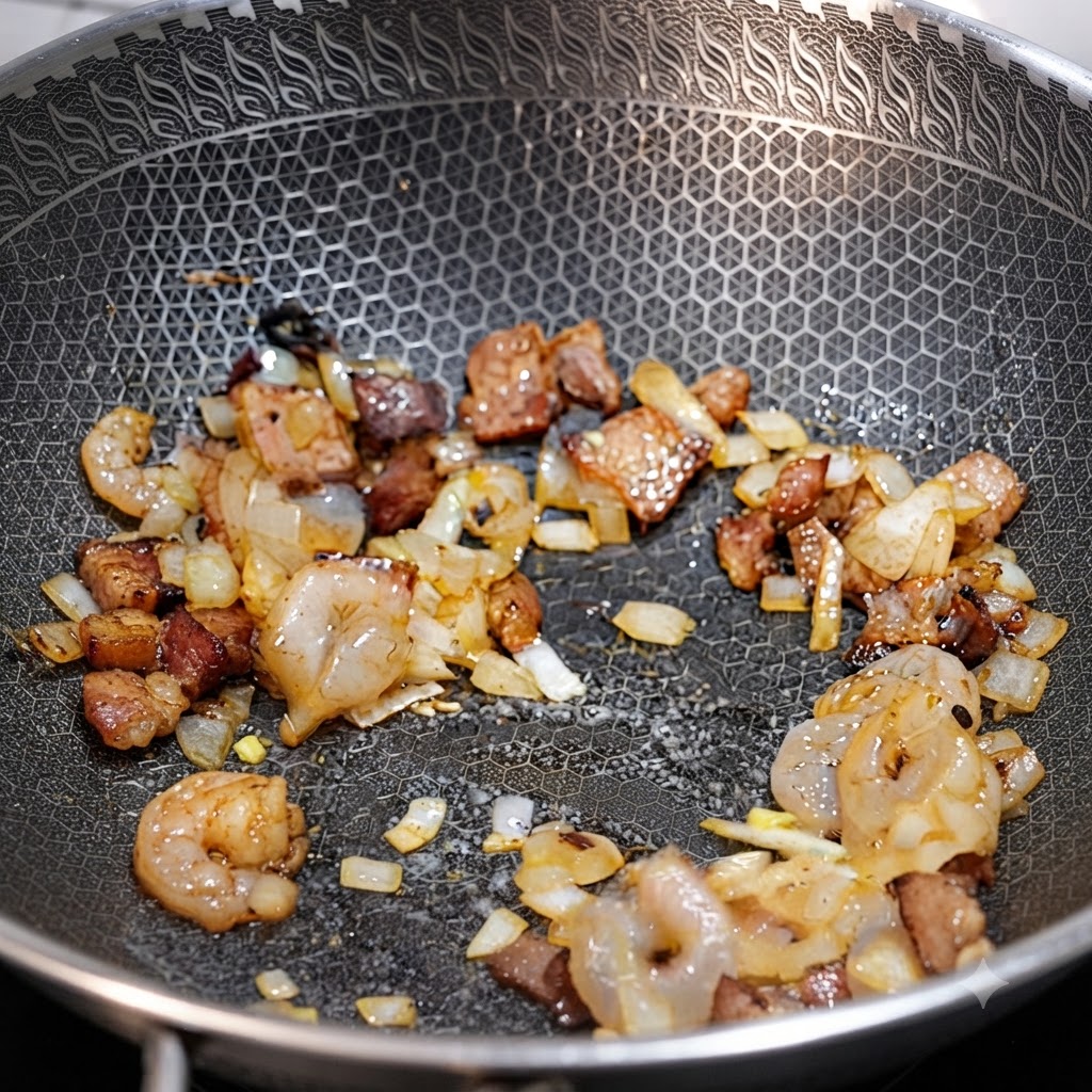 Garnelen, Speckstücke und gewürfelte Zwiebeln braten zusammen in einem Wok.