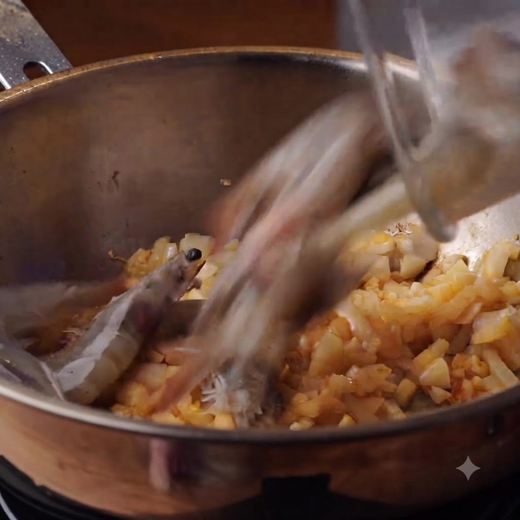 Frische ganze Garnelen werden in einen Topf mit angebratenen Zwiebeln und Knoblauch gegeben.