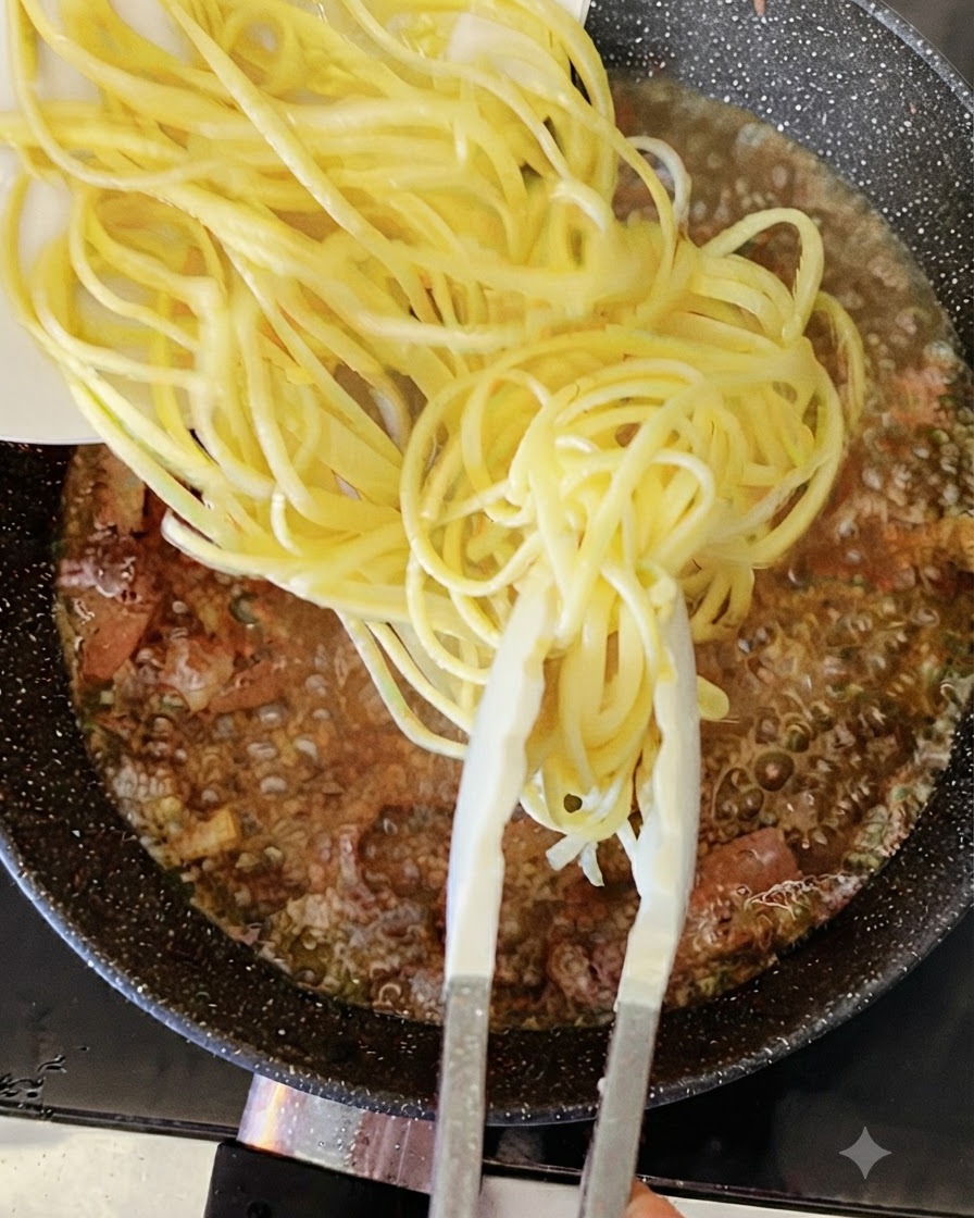 Gekochte gelbe Spaghetti-Nudeln werden mit einer Zange in eine blubbernde Pfanne mit Flüssigkeit und Speck gegeben.